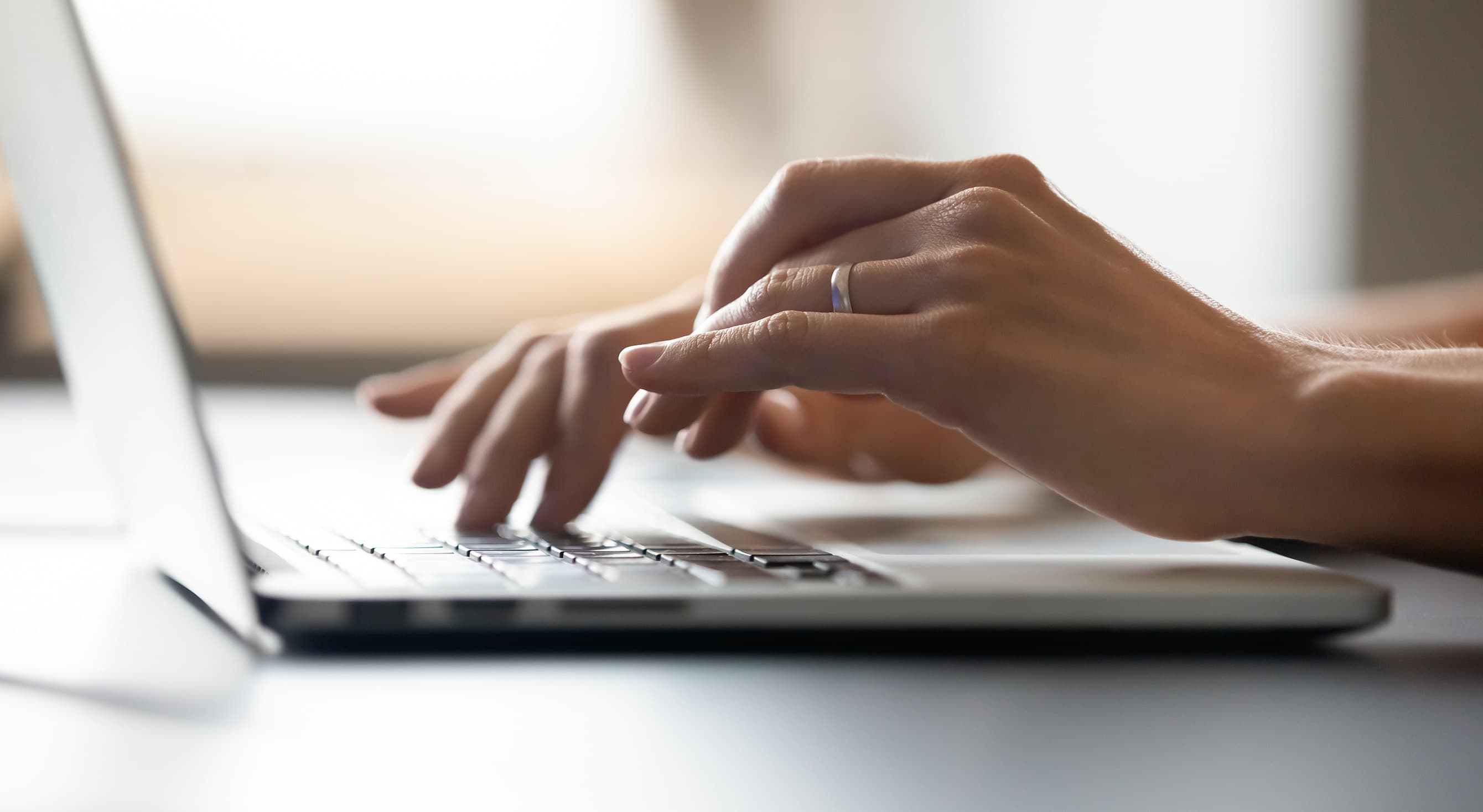 Close up of hands on the keypad of a laptop