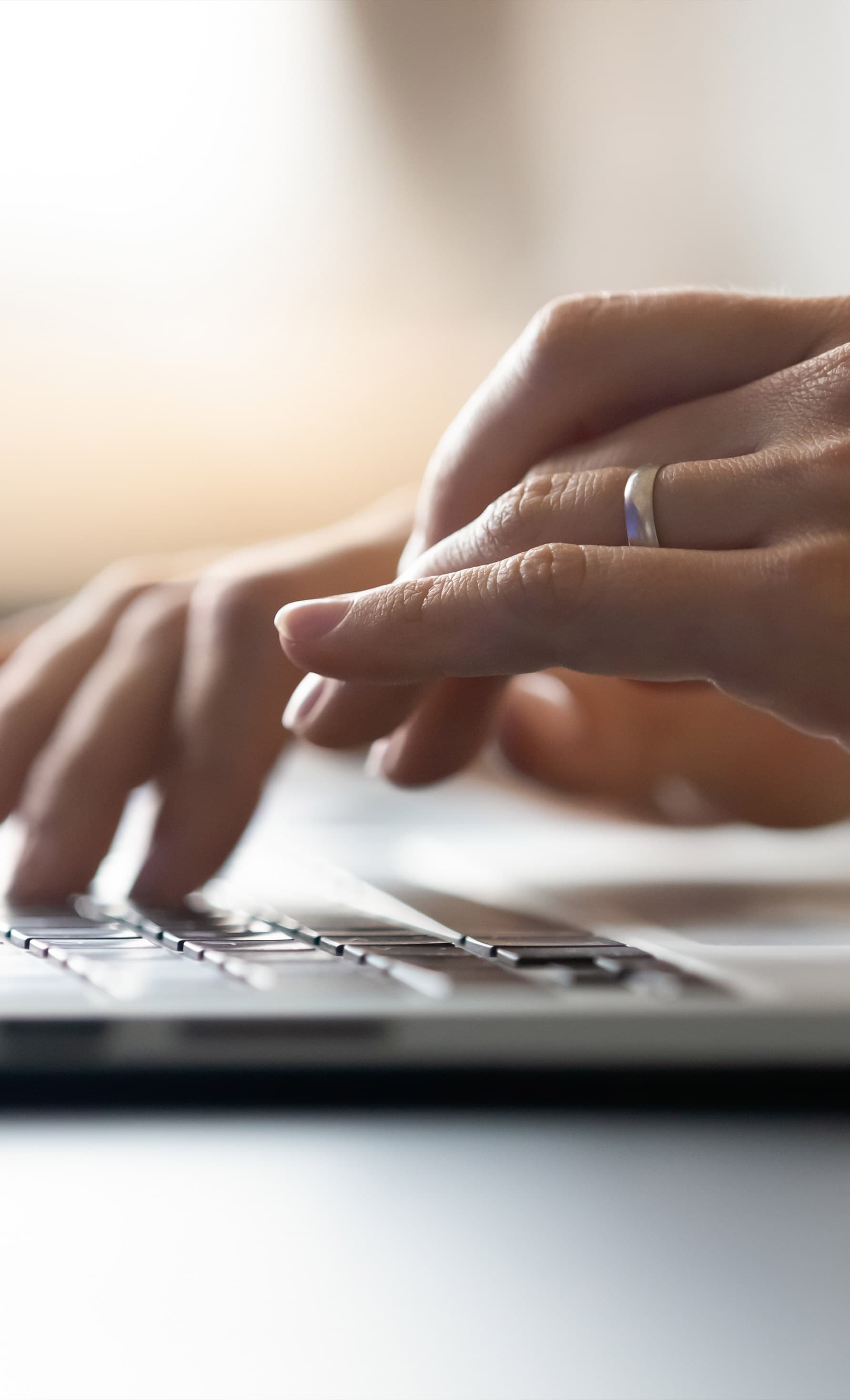 Close up of hands on the keypad of a laptop